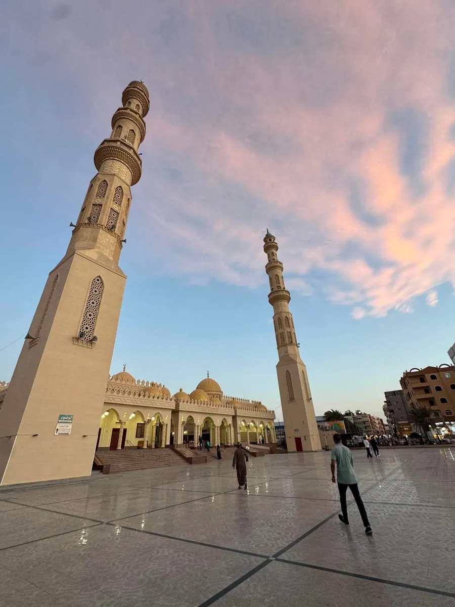 Meczet z dwoma minaretami w Hurghadzie, różowo fioletowe niebo o zachodzie nad pustym placem