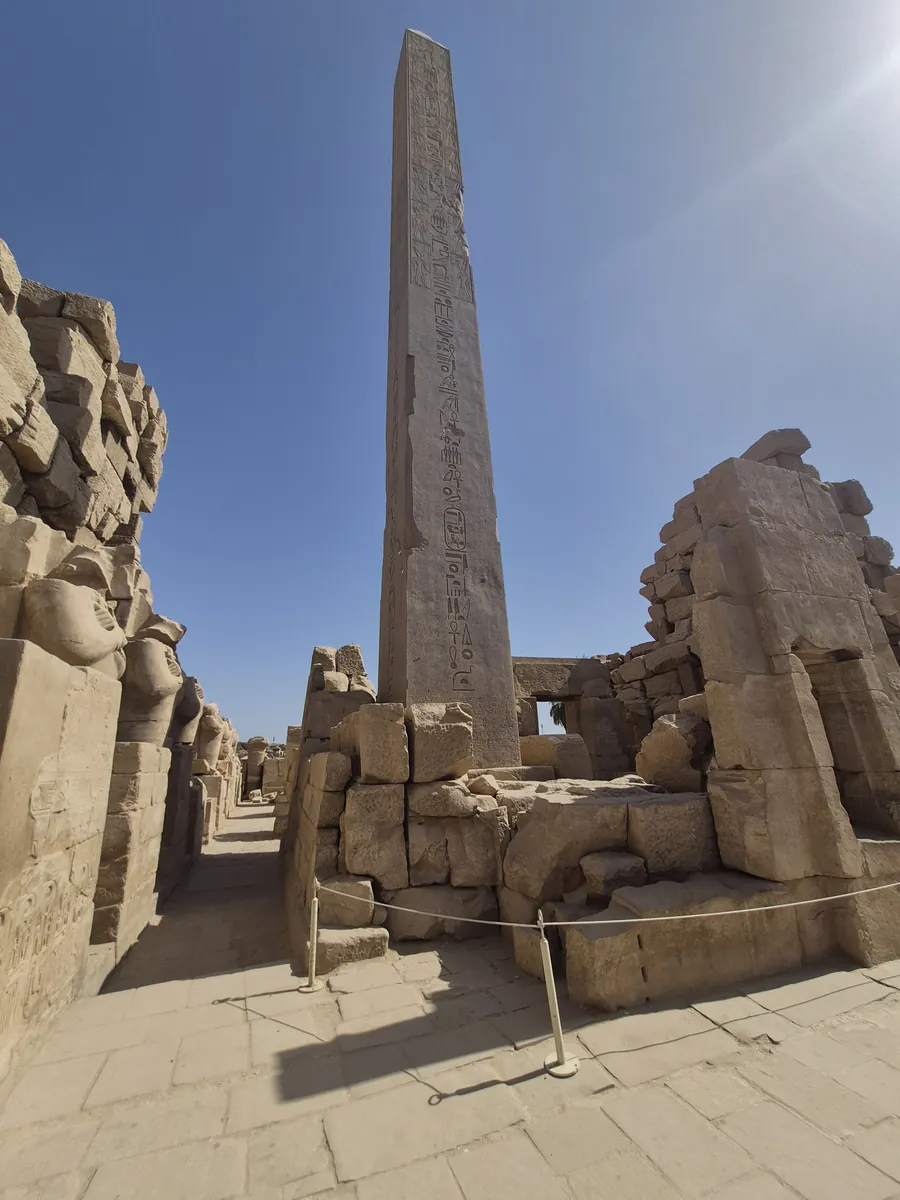 Obelisk pokryty hieroglifami na tle czystego nieba w Karnaku
