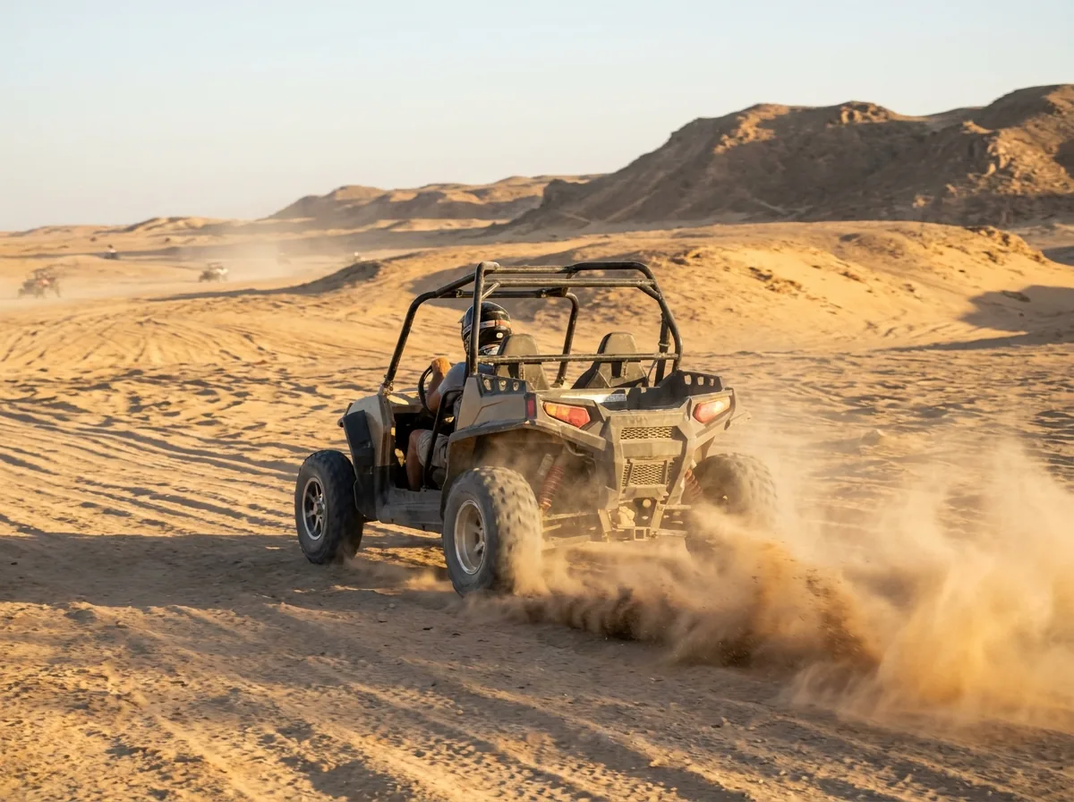 Buggy pustynny w ruchu, tuman piasku za pojazdem